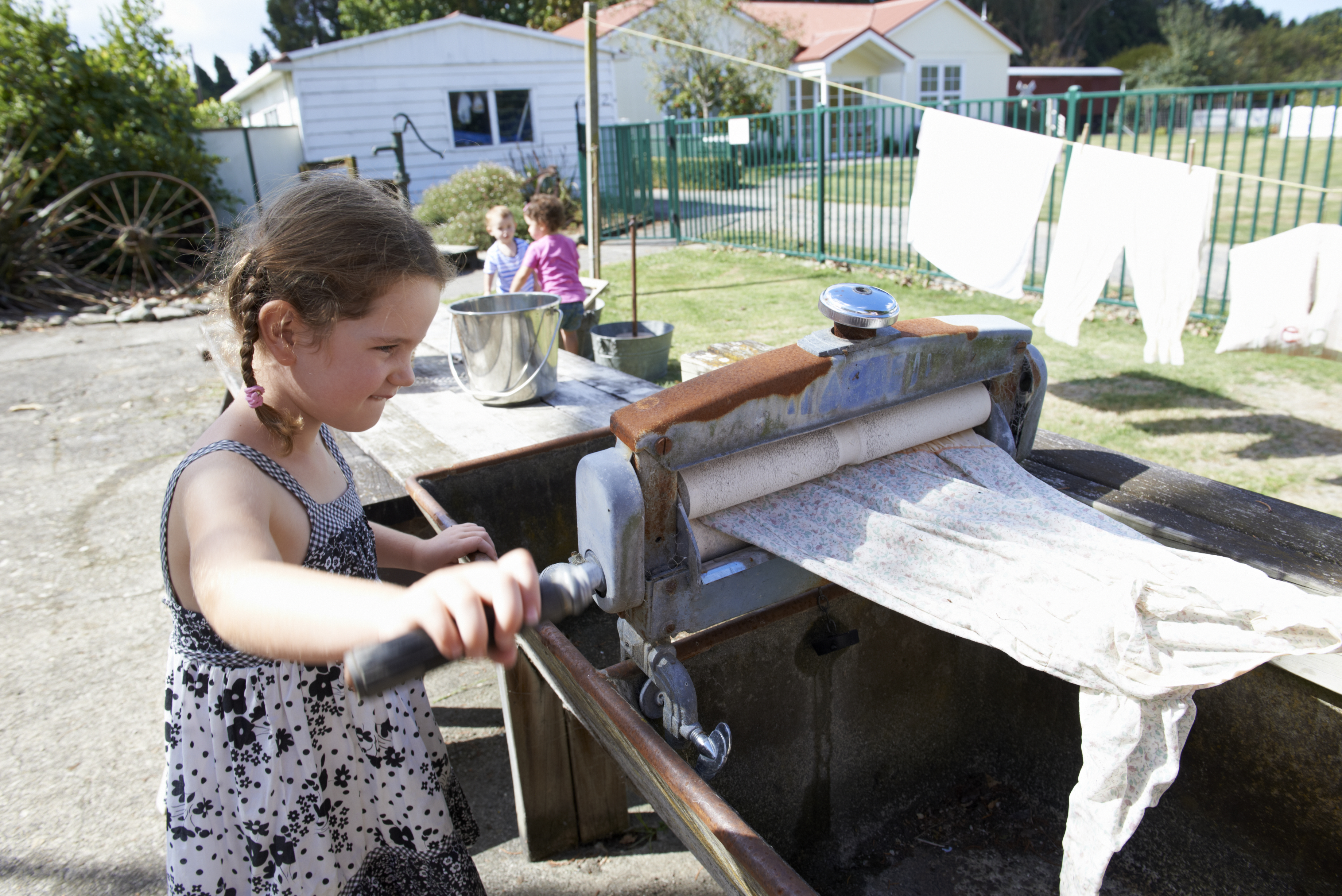 Girl operating a laundry straining roller